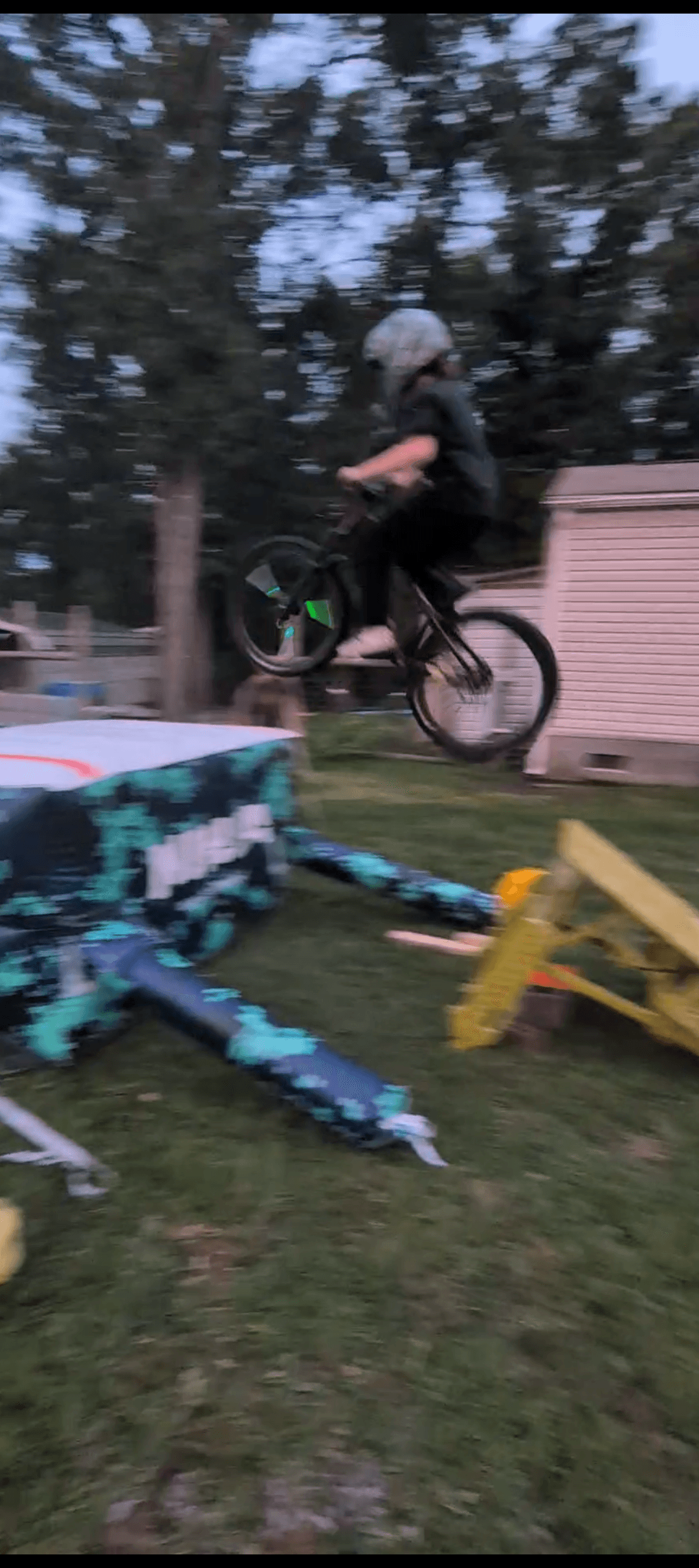 Logan Bowes mid-jump on his BMX bike over the air bag ramp